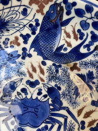 Plat en porcelaine de Chine en bleu, blanc et rouge de cuivre &agrave; d&eacute;cor de poissons et d'un crabe, Kangxi