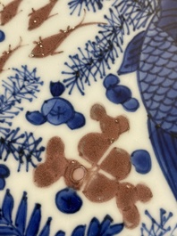 Plat en porcelaine de Chine en bleu, blanc et rouge de cuivre &agrave; d&eacute;cor de poissons et d'un crabe, Kangxi