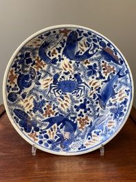 Plat en porcelaine de Chine en bleu, blanc et rouge de cuivre &agrave; d&eacute;cor de poissons et d'un crabe, Kangxi