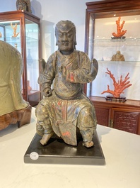 A Chinese lacquered and polychromed wood sculpture of a Buddhist guardian, Ming
