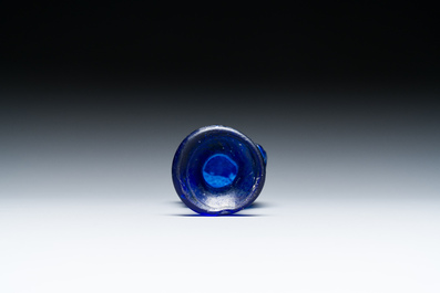 A Roman &lsquo;Sidonian&rsquo; dark blue 'erotic subject' molded glass bottle, Eastern Mediterranean, ca. 1st C.