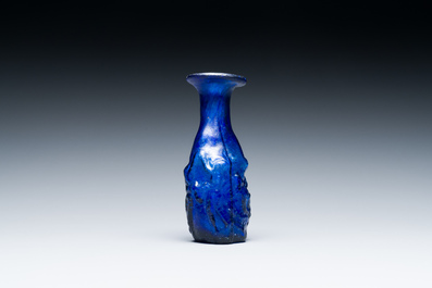 A Roman &lsquo;Sidonian&rsquo; dark blue 'erotic subject' molded glass bottle, Eastern Mediterranean, ca. 1st C.