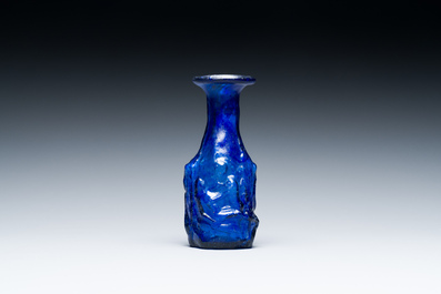 A Roman &lsquo;Sidonian&rsquo; dark blue 'erotic subject' molded glass bottle, Eastern Mediterranean, ca. 1st C.