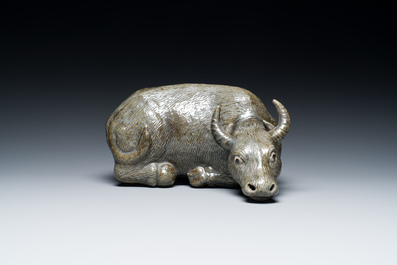 A Chinese monochrome brown-grey-glazed sculpture of a reclining water buffalo on wooden stand, 19th C.