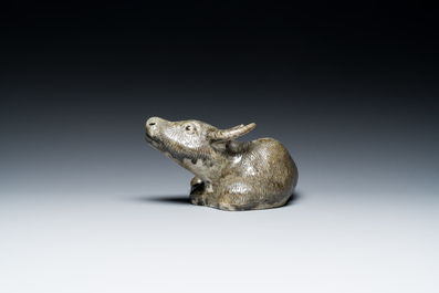 A Chinese monochrome brown-grey-glazed sculpture of a reclining water buffalo on wooden stand, 19th C.