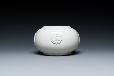Een Chinese wit-geglazuurde kom met reli&euml;fdecor, Qianlong merk, 19e eeuw