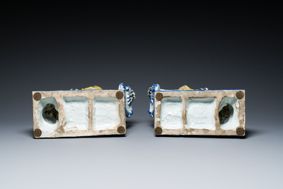 A pair of polychrome French faience lions holding a monogrammed shield, probably Rouen, 18/19th C.