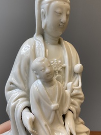 Een Chinese Dehua blanc de Chine figuur van Guanyin met een jongen, Kangxi/Qianlong