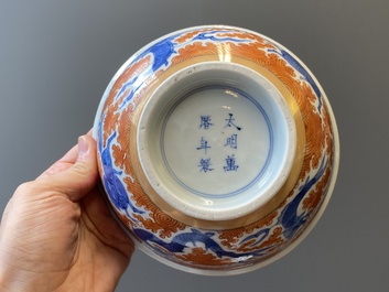 A Chinese blue, white and iron-red 'dragon' bowl and a famille rose 'immortals' bowl, Jiaqing and Wanli mark, 19th C.