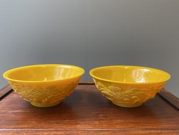 A pair of Chinese yellow Beijing glass bowls with figures in mountainous landscapes, 19/20th C.