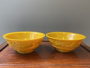 A pair of Chinese yellow Beijing glass bowls with figures in mountainous landscapes, 19/20th C.