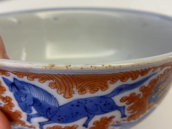 A Chinese blue, white and iron-red 'dragon' bowl and a famille rose 'immortals' bowl, Jiaqing and Wanli mark, 19th C.