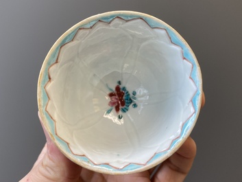 A pair of Chinese relief-decorated famille rose 'lotus' cups and saucers with a scholar and his servant, Yongzheng