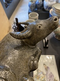 A Chinese monochrome brown-grey-glazed sculpture of a reclining water buffalo on wooden stand, 19th C.