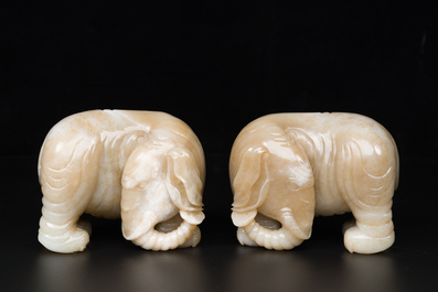 Een paar Chinese witte en roodbruine jade sculpturen van een olifant, Qianlong