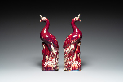 A pair of Chinese flamb&eacute;-glazed models of peacocks on wooden stands, 19th C.