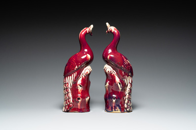 A pair of Chinese flamb&eacute;-glazed models of peacocks on wooden stands, 19th C.