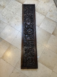 A sculptured walnut panel with putti, allegorical characters and human-headed dragons around an ecusson, presumably France, 16th C.