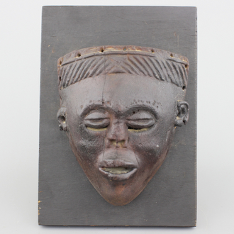 An African carved wood Chokwe mask, mounted on wood, early to mid 20th C.