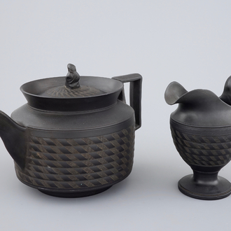 A Wedgwood black basalt teapot and cream jug, 19th C.