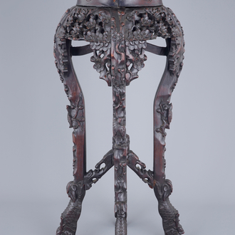 A richly carved Chinese wood stand with marble top, 19/20th C.