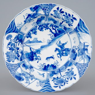 A deep Chinese blue and white plate with a battle scene on horseback, Kangxi