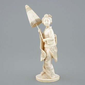 A Japanese carved ivory okimono of a lady holding a parasol, 19th C.