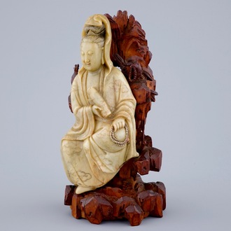 Een fraaie Guanyin in zeepsteen op een houten sokkel, 18/19e eeuw