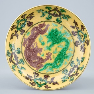 A Chinese yellow-ground saucer with incised green and aubergine dragons, Kangxi mark, 19/20th C.