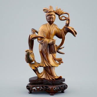 Een Chinese gesculpteerd Guanyin in tijgeroog op houten basis, 19/20e eeuw