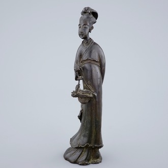 A Chinese bronze figure of a lady with a flower basket, 18/19th C.