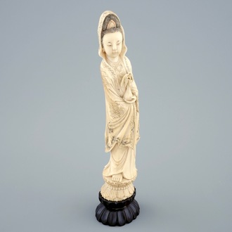 A Chinese carved ivory figure of Guanyin on a wooden base, 19th C.