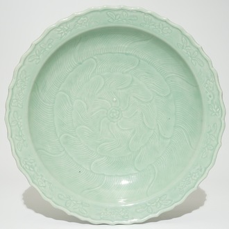 Een Chinese monochrome celadon schotel met floraal onderglazuur decor, Qianlong