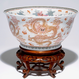 Un grand bol en porcelaine de Chine famille rose aux dragons sur socle en bois, 20ème