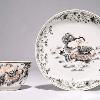 Une tasse et soucoupe à décor romantique en porcelaine de Chine grisaille, doré et rouge de fer, Qianlong