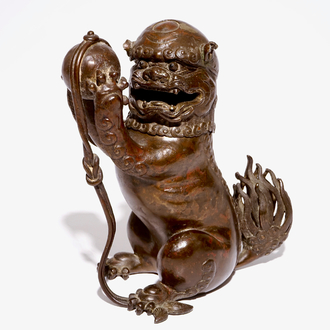 A Chinese lacquered bronze censer modelled as a buddhist lion with a brocade ball, Ming