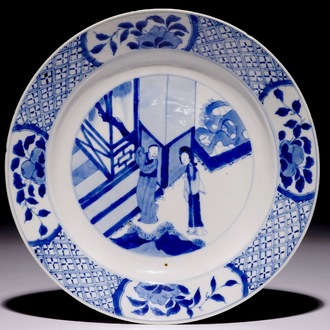 Une assiette en porcelaine de Chine bleu et blanc à décor de personnages dans un jardin, marque et période de Kangxi