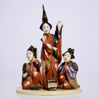 Een polychrome Japanse ivoren okimono van dames bij een cadeau, Meiji, begin 20e eeuw