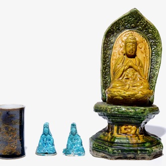 A Chinese sancai Buddha on a throne, two turquoise Guanyin figures and a black and gilt brushpot, 18/19th C.