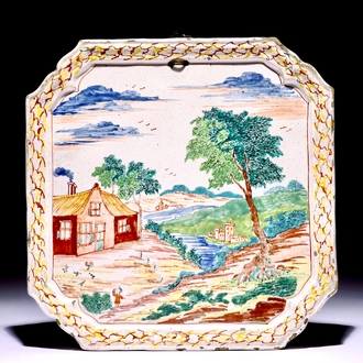 A square Dutch Delft polychrome petit feu plaque with a landscape, 18th C.