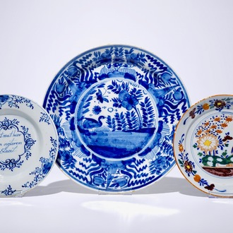 A Dutch Delft blue and white chinoiserie dish, an inscribed plate and a polychrome plate with floral design, 18th C.