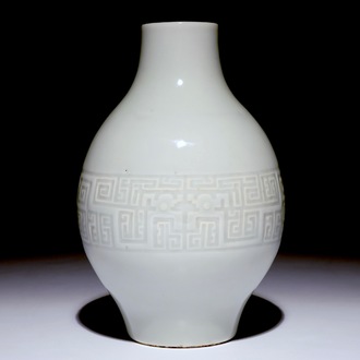 A Chinese monochrome white-glazed olive-shaped vase with underglaze design, Qianlong mark,  19th C.