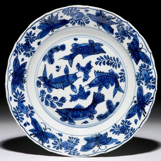 Een Chinees blauwwit bord met karpers en vlinders, Wanli