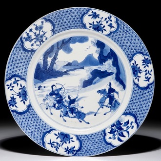 Un plat en porcelaine de Chine bleu et blanc à décor d'une chasse, marque de Chenghua, Kangxi