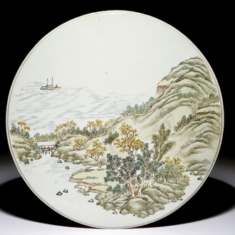 Une plaque ronde en porcelaine de Chine polychrome à décor d'un paysage, 19/20ème