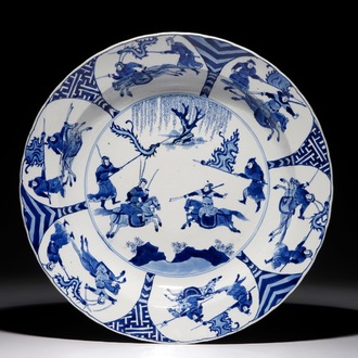 Un plat en porcelaine de Chine bleu et blanc à décor d'une bataille, marque de Chenghua, Kangxi