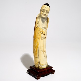 A Chinese ivory figure of the immortal Han Zhongli, on wooden base, late Ming