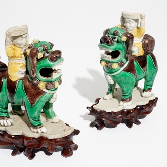 A pair of Chinese verte biscuit joss stick holders shaped as warriors on Buddhist lions, Kangxi