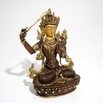 A Sino-Tibetan gilt bronze figure of Manjusri with coral and turquoise insets, 19/20th C.