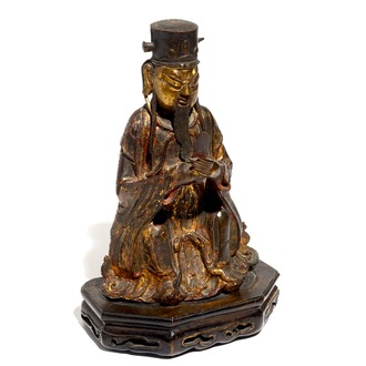 A Chinese partly gilt and polychrome bronze figure of Wenchang Dijun on wooden stand, Ming